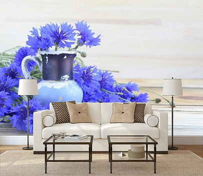 Синие васильки и кувшин в интерьере гостиной с диваном