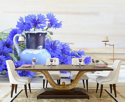 Синие васильки и кувшин в интерьере кухни с большим столом